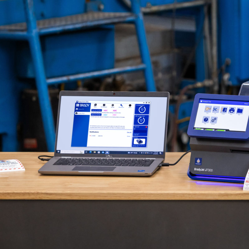 En bärbar dator som är ansluten till en J7300 visar en skärm från Brady Workstation.