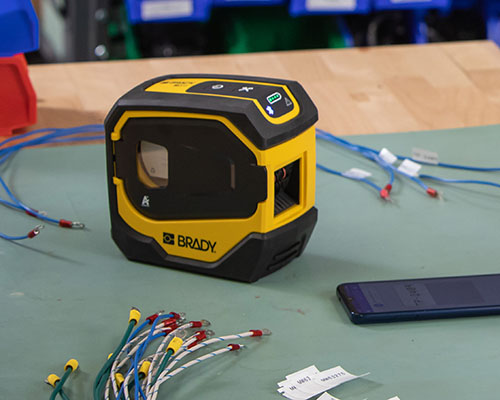 M511-skrivaren med märkta ledningar och en mobiltelefon.