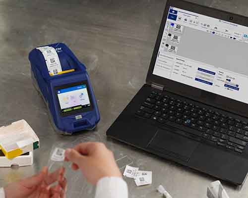 En person som applicerar en M611-utskriven etikett på ett labbobjektglas.