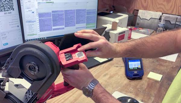 En person pekar ut en etikett på ett verktyg.